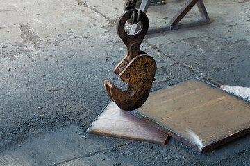 Clamp for lifting sheet metal with a crane. Clamp for moving metal plates with thick metal plates lying next to them