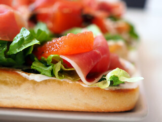 Close-Up of Bruschetta with Iberico Ham, Quince Paste, Romaine Lettuce, and Cream Cheese on Toast