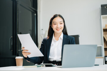 Business woman using tablet and laptop for doing math finance on an office desk,