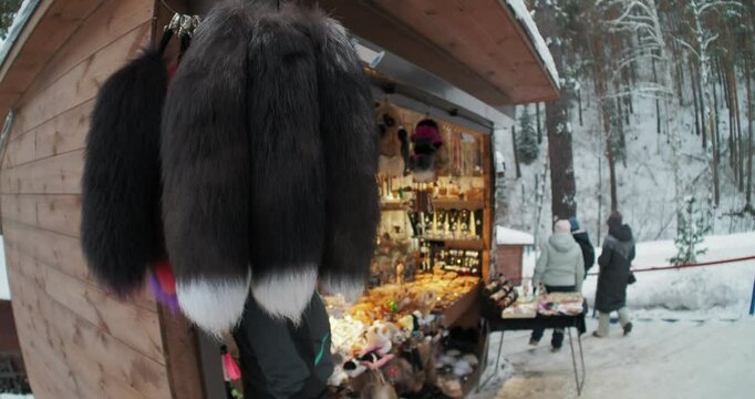 Retail trade. People passed by a small shop selling painted fox tails and various souvenirs. Hand held. Siberia.