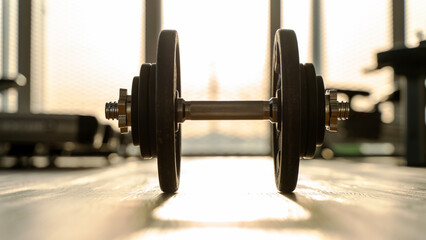 barbell or dumbbell in the gym during sunset