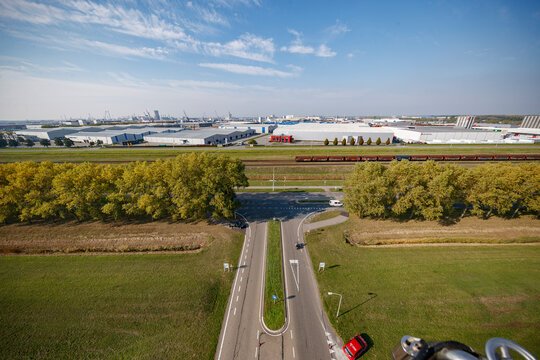 Industrial landscape with railway and highway seen from above on a clear day near an urban area