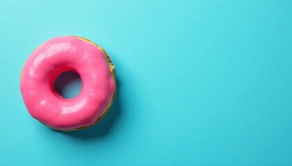 A delicious pink donut resting on a vibrant blue background, perfect for desserts.