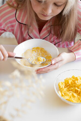 girl eating cornflakes with milk for breakfast, american breakfast