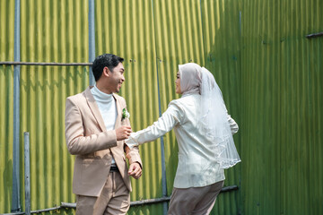 A couple on Valentine's Day holding hands while joking happily in the public area