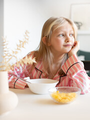 girl eating cornflakes with milk for breakfast, american breakfast