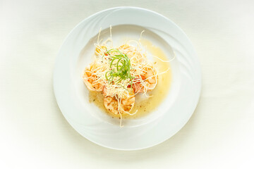 A plate of food with shrimp and noodles on top