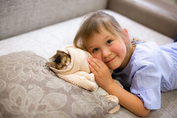 A six years old girl with a small Abyssinian kitten.