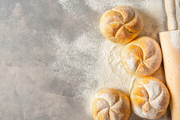 Freshly baked golden bread rolls with rolling top view copy space. Bakery concept