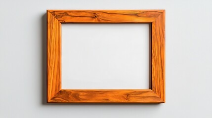 A simple wooden picture frame with a blank interior, set against a light-colored wall, inviting creativity and personal expression.