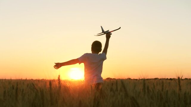 boy teenager child kid runs through field with wheat with toy plane his hands sunset, happy dream family, child wants become pilot pilot astronaut, holding airplane his hands, pilot flight astronaut