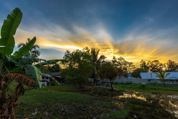 Beautiful panoramic nature background of colorful twilight sky amidst community houses, countryside...