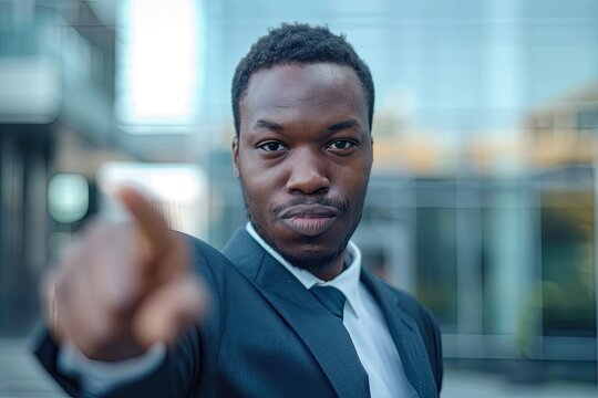 Handsome businessman pointing finger at virtual image  shallow depth of field.