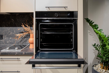 Black built-in oven with open door and visible cooking racks
