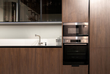 Built in oven and microwave set in wood cabinetry for modern kitchen