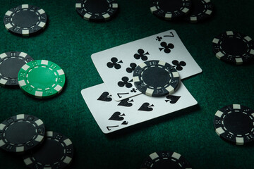 Game environment on the table in a poker club with a combination of cards one pair and chips. A...