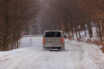 Obraz premium Car on the snowy mountain road during severe conditions