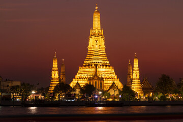 Naklejka premium Wat Arun Ratchawararam Ratchawaramahawihan or Wat Arun (Temple of Dawn) is a Buddhist temple along the Chao Phraya river at twilight in Bangkok, Thailand.