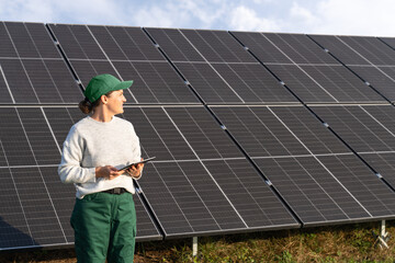 Female farmer with digital tablet on a modern farm using solar panels