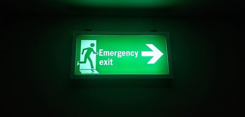 Green illuminated emergency exit sign with running person icon