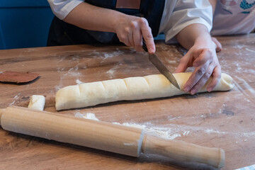 Woman preparing traditional cinnamon rolls in kitchen