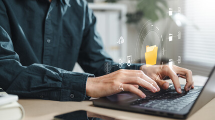 document, file, folder, management, report, information, finance, financial, insurance, search. A man is typing on a laptop with a folder icon on the screen. Concept of technology and productivity.