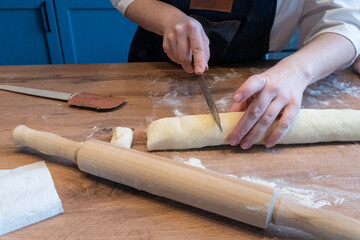 Woman preparing traditional cinnamon rolls in kitchen