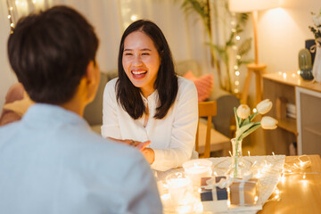 diner, valentine, celebrate, loving, affection, romantic, romance, couple, affectionate, date. A man and a woman are sitting with a vase of flowers in front of them. Scene is happy and romantic.