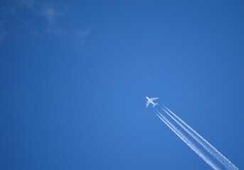 a jet flying through a blue sky leaving a trail of smoke 