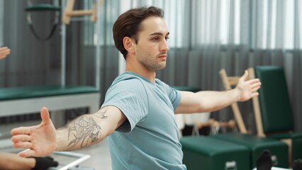 Two clients performing synchronized arm extensions on Pilates reformer machines. Happy pilates...