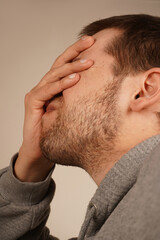 Obraz premium The man places his palm on his face, performing a facepalm gesture. This classic gesture expresses frustration, disbelief, or embarrassment. It s a universal sign of exasperation or regret.