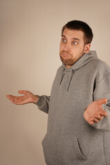 With hands extended outward, a man shrugs, appearing confused. The open palms symbolize his lack of understanding about the situation. His body language reflects uncertainty and wonder.