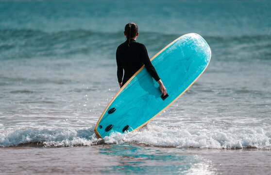 Female surfer with surf board beach sea scene