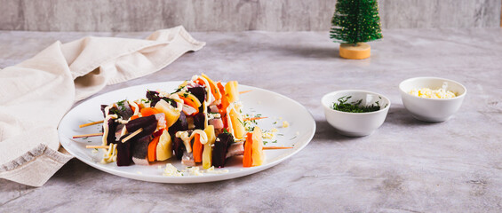 Unusual herring under a fur coat on skewers on the table web banner
