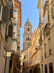 wonderful calm alley in the old town of Málaga with a view towards the tower of the catholic cathedral Santa Iglesia Catedral Basílica de la Encarnación, Málaga, Costa del Sol, Andalusia, Spain