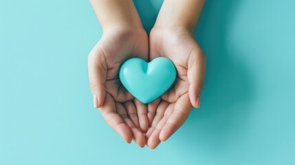 Fototapeta premium Female hands on a blue background holding a blue heart. The concept of donations and family insurance, World Heart Day. valentine's day.