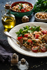White beans with cherry tomatoes, parmesan, lemon and garlic on black table