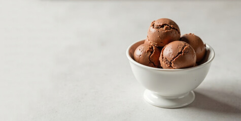 Ice cream balls lay in white creamer. Chocolate ice cream. Color mocha mousse 2025. Copy space