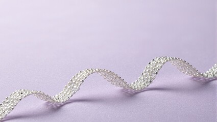 Elegant pearl ribbon on lavender velvet with soft highlights and shadows
