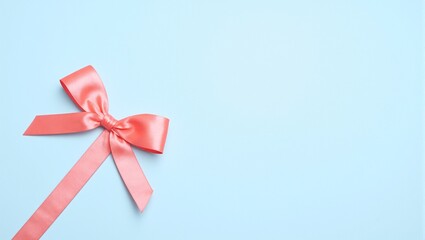Elegant coral ribbon bow on matte powder blue background