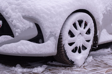 Tire of car with snow and ice in snowy winter day