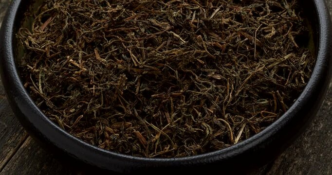 Dried Jimbu (Jimmu, Jamboo, Faran) in a bowl - a herb belonging to the onion family, used extensively in Nepal and in some central Himalayan states of India. Table spin.