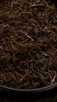Dried Jimbu (Jimmu, Jamboo, Faran) in a bowl - a herb belonging to the onion family, used extensively in Nepal and in some central Himalayan states of India. Table spin. Vertical video.