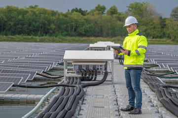 Obraz premium Engineer working at floating solar farm,checking and maintenance with solar batteries near solar panels,supervisor Check the system at the solar power station