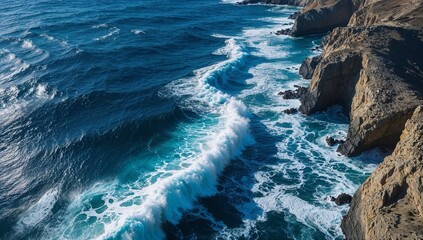 Aerial view of powerful ocean waves breaking against a dramatic rocky coastline. Stunning natural landscape.