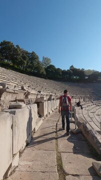 Man walking on Ancient theatre at the Asclepieion of Epidaurus in Greece, vertical video