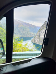 View of the Hagatunnel road in Steine, South Norway, with dramatic cliffs, green fields, and autumn colors.