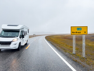 Camper van traveling on the e69 road to nordkapp, norway, on a rainy and foggy day