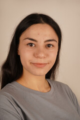 Her natural beauty and soft expression convey peace and tranquility. The composition highlights simplicity and ease. A close-up of a woman's face showcases her calm and relaxed demeanor.