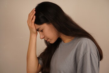 The photo captures a genuine moment of realization. The girl touches her head with both hands,...